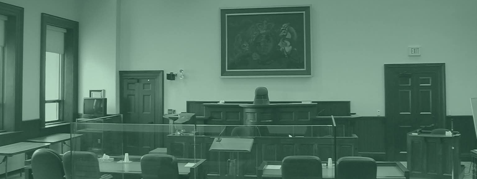 An empty courtroom, judge's bench and counsel tables
